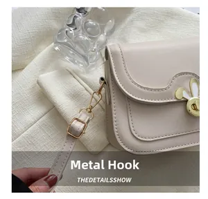 Detail of the golden bunny-ear metal lock and high-quality hardware hook on beige bag