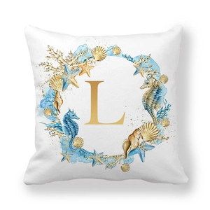 Detail of nautical wreath print with golden letter L on a soft white peach skin cushion cover