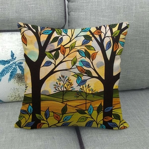Leinen-Kissenbezug mit buntem Wald- und Baummotiv auf einem grauen Stoffsofa
