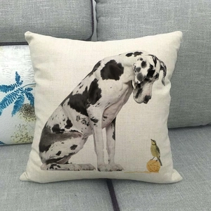 Detail of square linen pillow featuring a Great Dane and small bird on a grey sofa