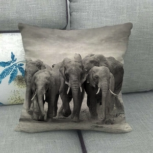 Detail of square elephant print throw pillow on sofa showing natural fabric texture
