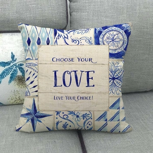 Blue geometric floral linen pillowcase with motivational quote on a grey sofa