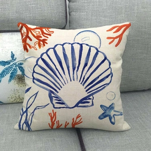Linen pillowcase with blue scallop and coral print on a dark gray sofa background