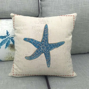 Detail of light blue starfish print on rustic linen cushion cover with French text