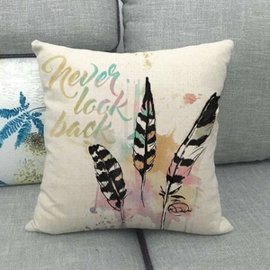 Cute bird feather linen pillow cover with never look back text on a grey sofa