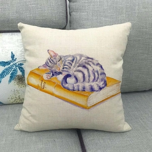 Detail of linen pillow cover with watercolor cat sleeping on books and textured fabric