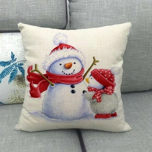 Linen Christmas pillow cover with cute snowman and penguin on a gray sofa