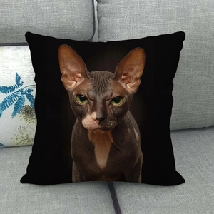 Close-up of a square black linen cushion cover with a realistic Sphinx cat print on a sofa