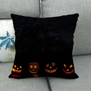 Close-up of Halloween linen pillowcase with pumpkin and bat prints on a grey sofa