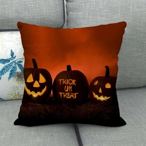 Detail of linen Halloween pillow cover with pumpkin trick or treat design on grey sofa