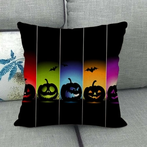Detail of Halloween bat and pumpkin linen pillowcase on a grey fabric sofa