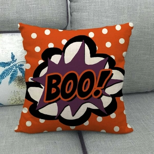 Detail of linen Halloween pillow cover with orange polka dots and BOO text on sofa