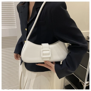 Gros plan d'un sac baguette blanc avec une grande boucle mate porté par un mannequin