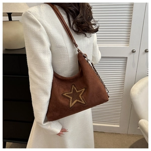 Brown suede shoulder bag with star embroidery and metal chain strap shown on model