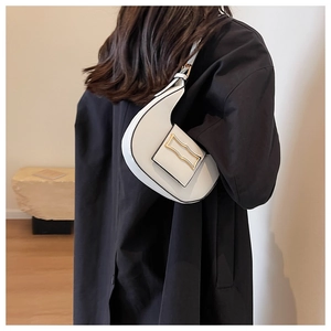 White crescent underarm bag shown on a model's shoulder for size reference and scale