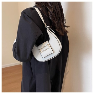 Close-up of white crescent hobo shoulder bag with elegant gold metal buckle detail