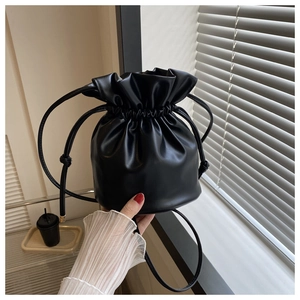 Detail of a black drawstring bucket bag in premium PU leather for casual daily commute