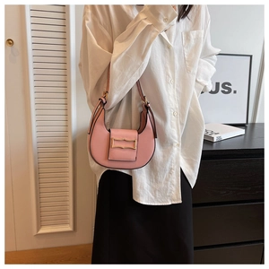 Detail of pink crescent bag with golden buckle styled on model in modern white shirt