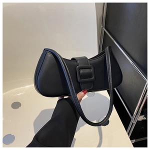 Détail du sac à bandoulière en cuir noir mat avec une boucle carrée élégante et minimaliste