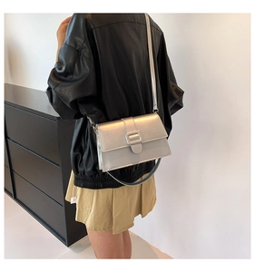 Close-up of a silver rectangular crossbody bag with a sleek metallic finish and shoulder strap