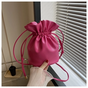Detailed view of hot pink bucket bag with drawstring closure and soft PU leather texture