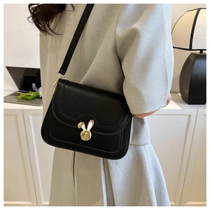 Detail of a vintage black crossbody bag with a distinctive golden rabbit metal clasp