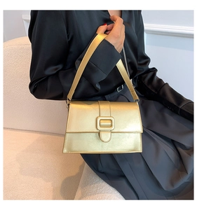 Close-up of a champagne gold leather crossbody bag with rectangle metal buckle