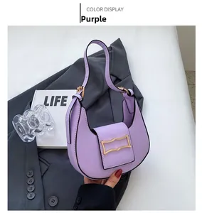 Detail of purple crescent shoulder bag with golden metal buckle on a grey suit jacket