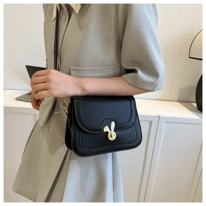 Detail of black leather crossbody bag featuring a unique gold rabbit head twist lock