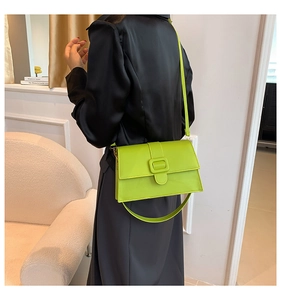 Detail of neon green patent leather square bag with matching buckle and dual straps