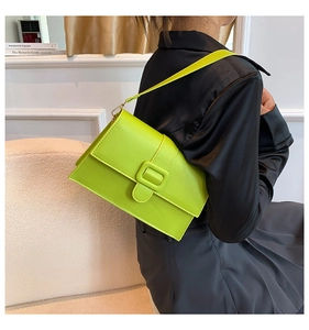 Close-up of lime green faux leather shoulder bag with a rectangular flap and matching buckle