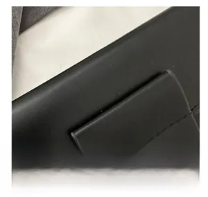 Close-up of black leather texture with gold metal chain strap and neat stitching detail