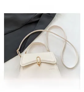 Detail of cream white leather handbag with golden oval twist lock and adjustable strap