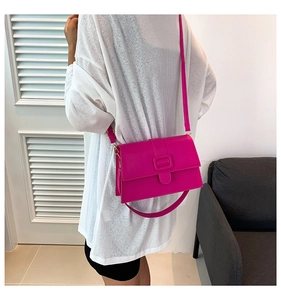 Model wearing a fuchsia square crossbody bag made of premium matte leather