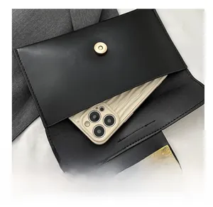 Detail shot of black envelope clutch with magnetic closure showing interior phone storage