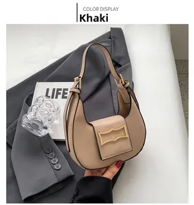 Detail of khaki crescent underarm bag with signature wavy golden metal buckle closure