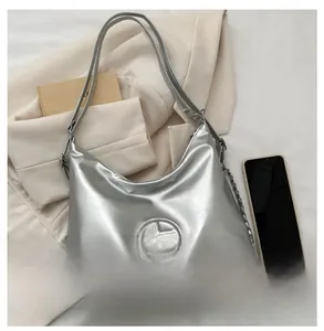 Sac fourre-tout argenté avec logo circulaire évidé et chaîne décorative en métal