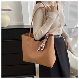 Brown leather tote bag featuring a stylish red and white checkered scarf accessory detail