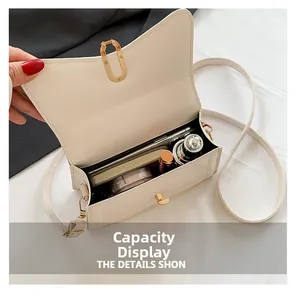 Interior view showing capacity of the cream crossbody bag with phone and lipstick