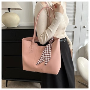 Detail of pink leather tote bag with checkered silk scarf and long shoulder straps