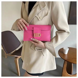 Detail of rose pink leather envelope clutch featuring a gold rectangular metal clasp
