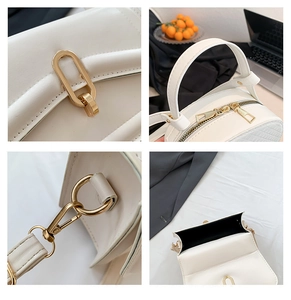 Detail view of white leather handbag showing gold lock, zipper, and detachable strap hooks