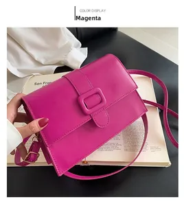 Detail of rose red rectangular shoulder bag featuring a matte finish and square buckle