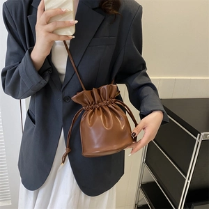 Bolso saco retro marrón con cordón, combinado con blazer para un estilo de oficina