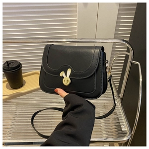 Close-up of black crossbody square bag with unique golden rabbit ear metal twist lock