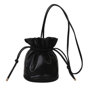 Minimalist black soft leather drawstring bucket bag with elegant golden hardware accents