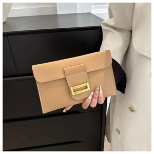 Detail of beige leather envelope clutch bag with textured metal buckle and fine stitching