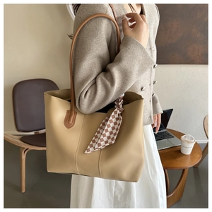 Chic khaki tote bag with plaid silk scarf detail shown in a cozy office setting
