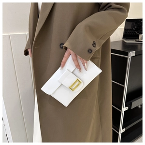 Close-up of white glossy envelope clutch bag featuring a sleek gold rectangular buckle