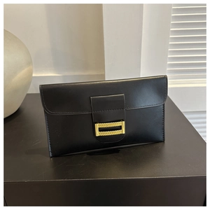 Close-up of black leather envelope clutch bag with textured gold metallic buckle detail